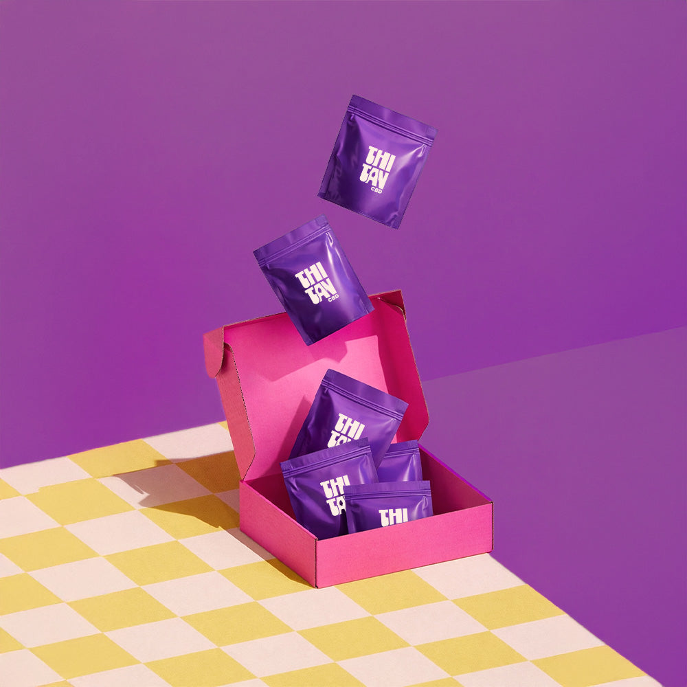 pochons de CBD qui tombent dans une boite cartonnée rose