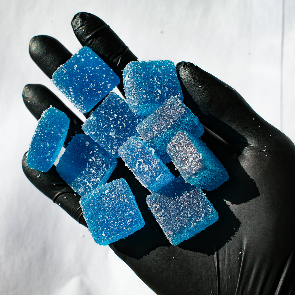 Tas de gummies au cbd bleus dans une main